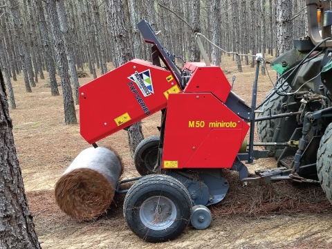 Mini round baler for pine straw baling.